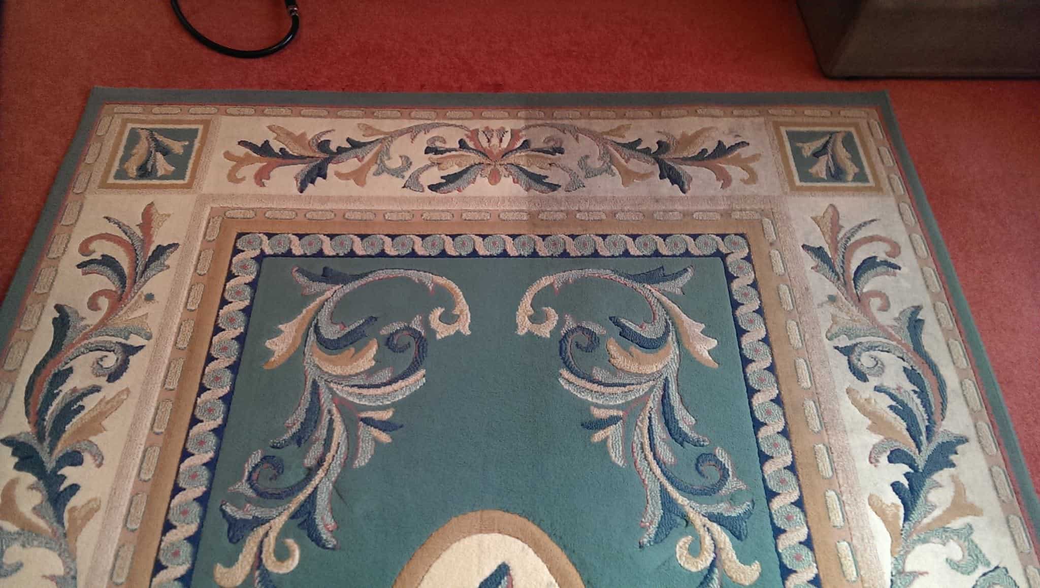 Ornate area rug showing the visible difference between cleaned and uncleaned halves